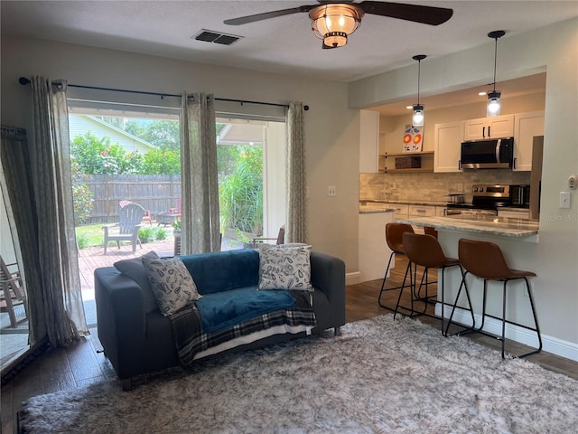 737 Butternut Pl, Lakeland, FL 33813 - living room with ceiling fan, dark wood finished floors, and baseboards