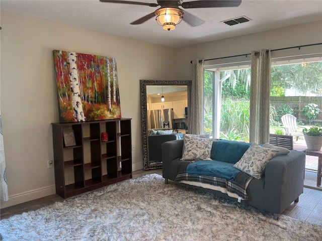 living room featuring hardwood / wood-style floors, ceiling fan, and a textured ceiling