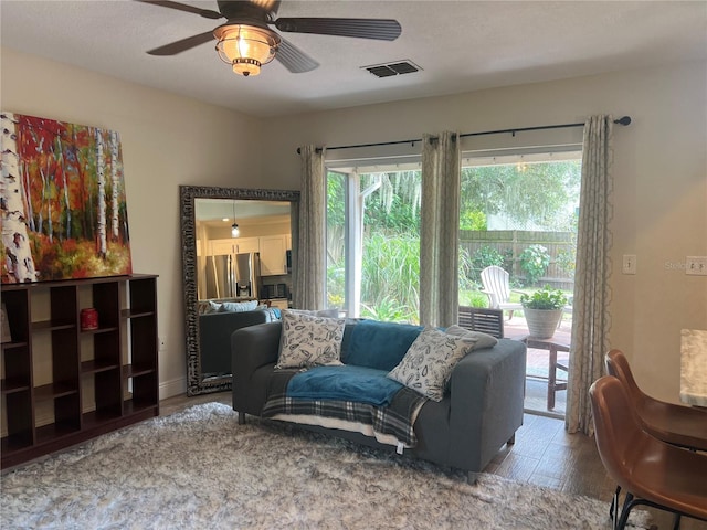 living room featuring ceiling fan and hardwood / wood-style flooring