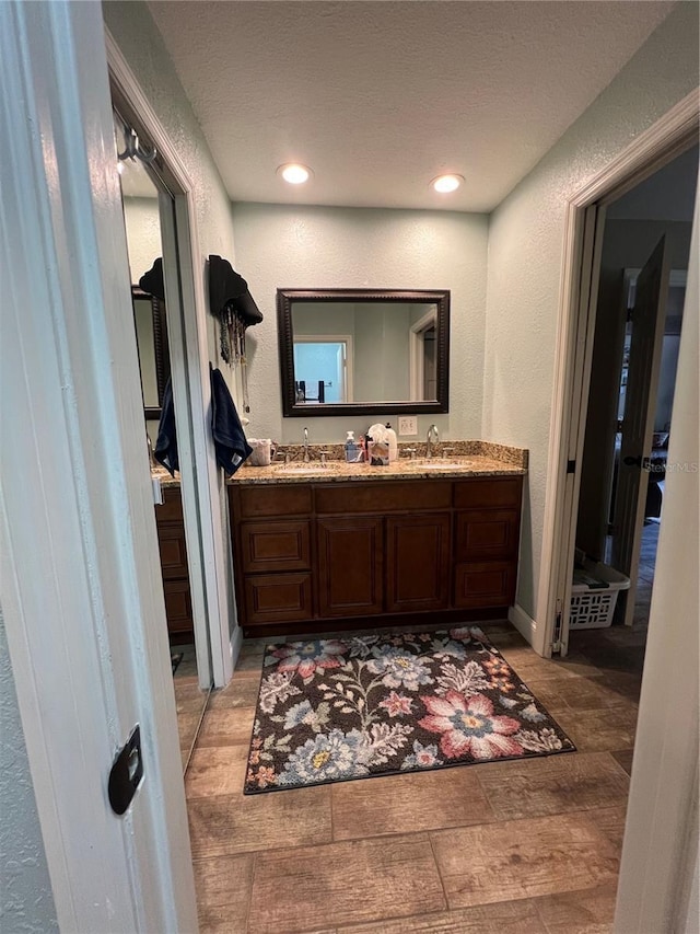 737 Butternut Pl, Lakeland, FL 33813 - bathroom featuring a textured wall, wood finished floors, double vanity, and recessed lighting