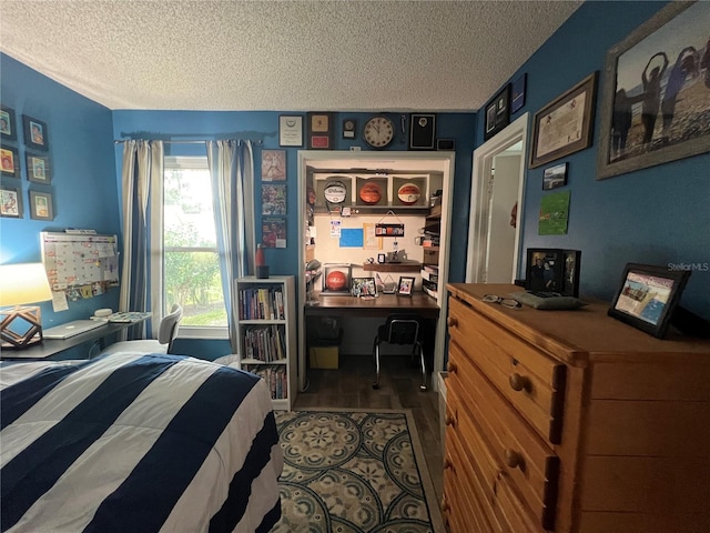 bedroom with dark hardwood / wood-style floors and a textured ceiling