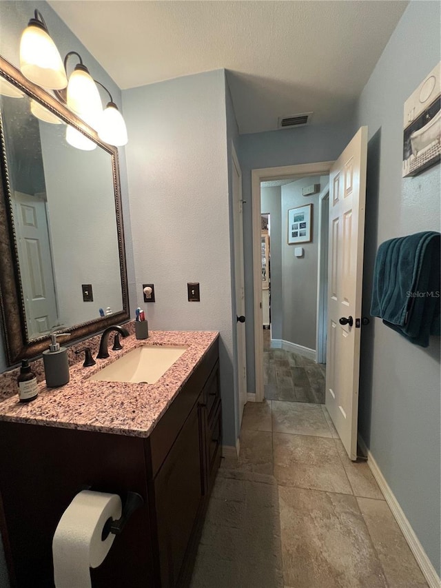 737 Butternut Pl, Lakeland, FL 33813 - bathroom featuring vanity, stone finish flooring, and baseboards