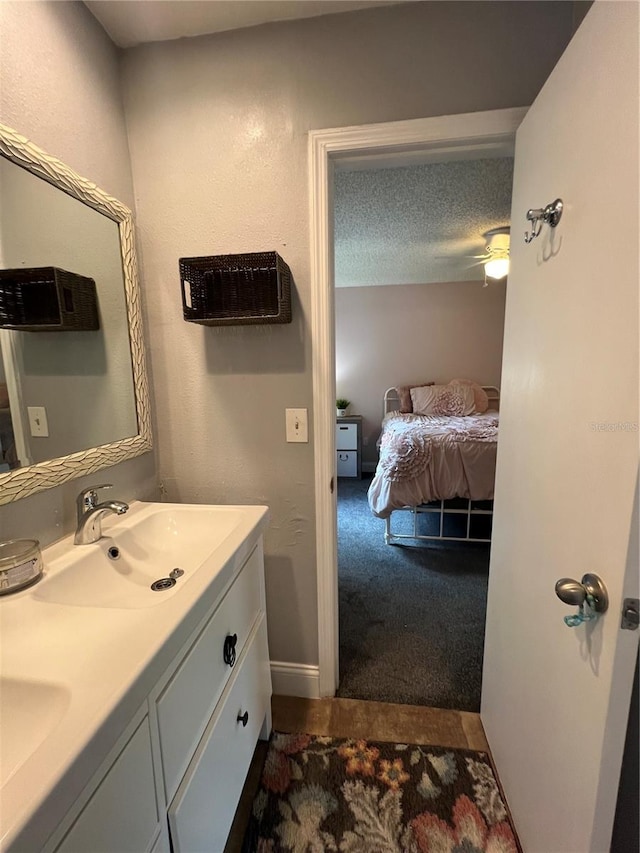 bathroom featuring vanity, ceiling fan, and a textured ceiling