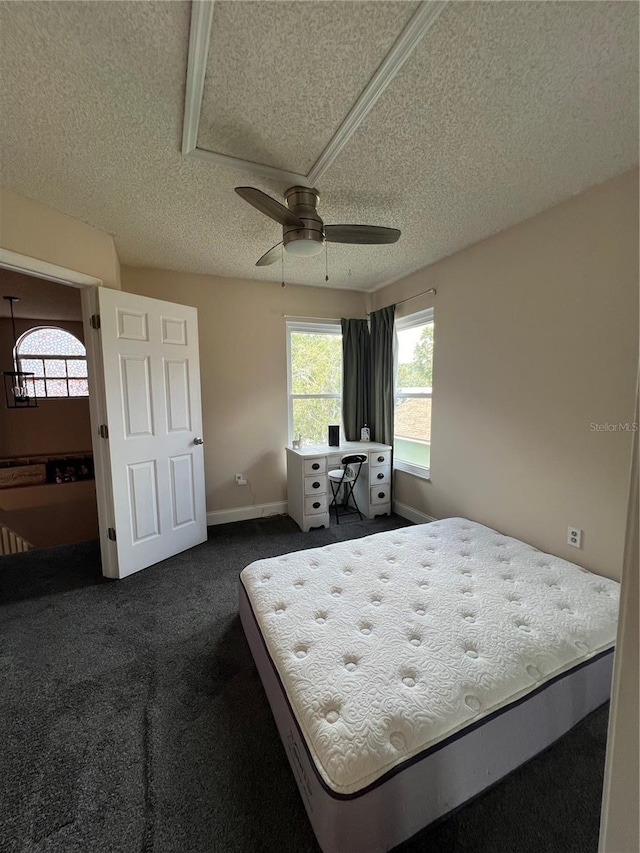 carpeted bedroom featuring a textured ceiling and ceiling fan