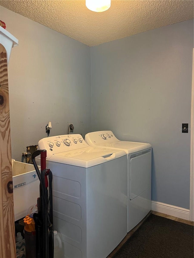 laundry area with separate washer and dryer and a textured ceiling