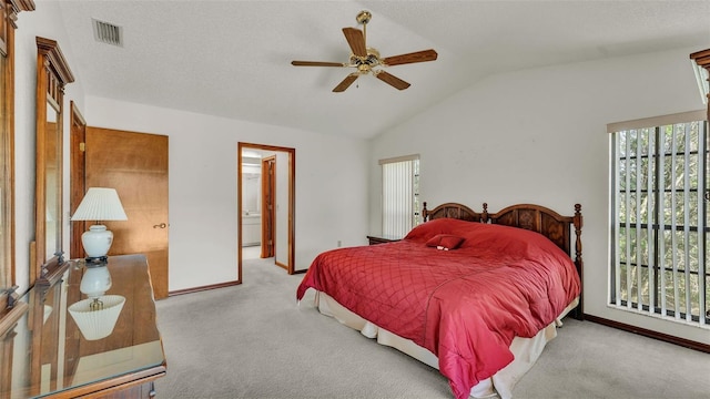 carpeted bedroom with ceiling fan, ensuite bath, a textured ceiling, and vaulted ceiling