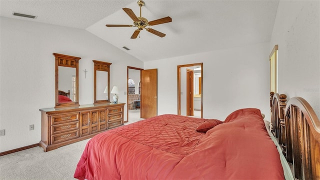 carpeted bedroom with a textured ceiling, vaulted ceiling, ensuite bath, and ceiling fan