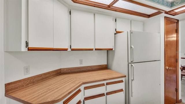 kitchen featuring white cabinets and white refrigerator