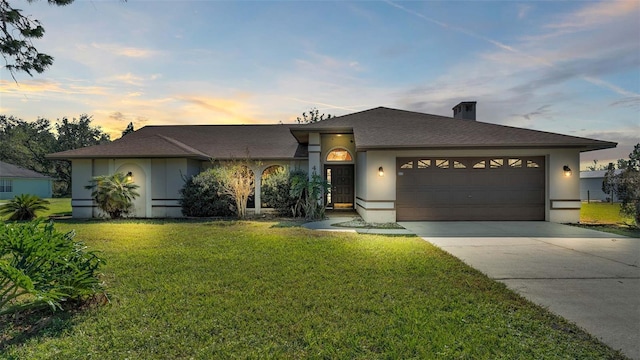 view of front of property with a lawn and a garage