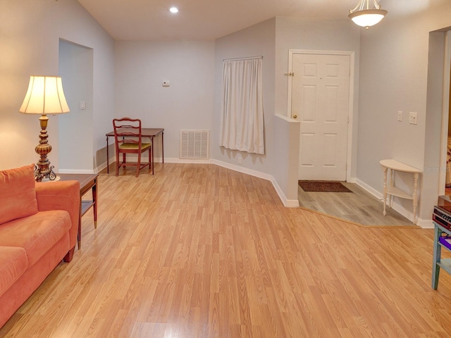 interior space featuring vaulted ceiling and light hardwood / wood-style floors