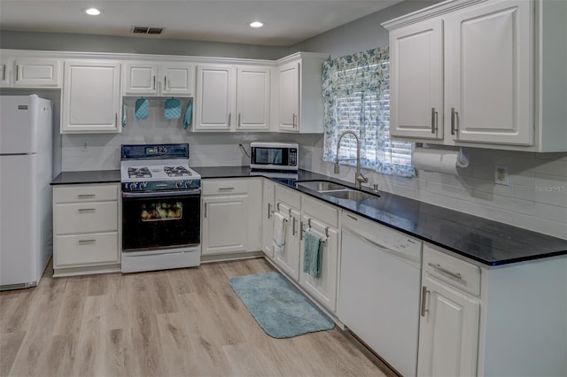 kitchen with white appliances, white cabinetry, decorative backsplash, sink, and light hardwood / wood-style flooring