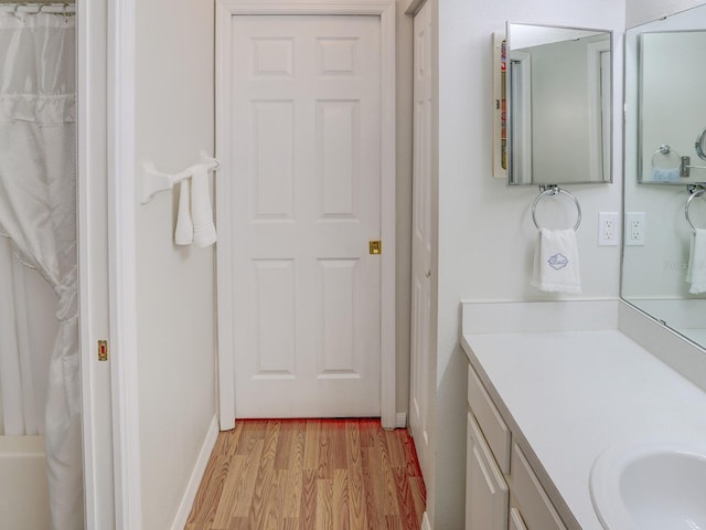 bathroom featuring hardwood / wood-style floors, walk in shower, and vanity