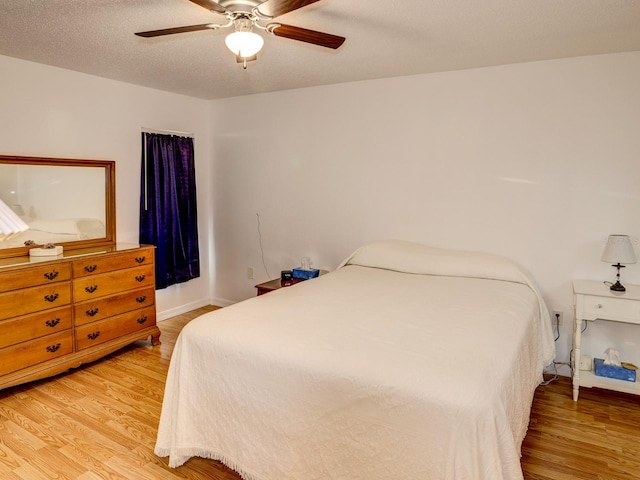 bedroom featuring a textured ceiling, ceiling fan, and hardwood / wood-style flooring