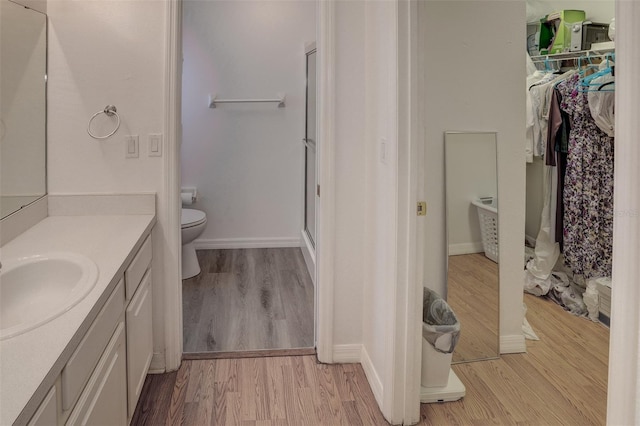 bathroom with a shower, wood-type flooring, toilet, and vanity