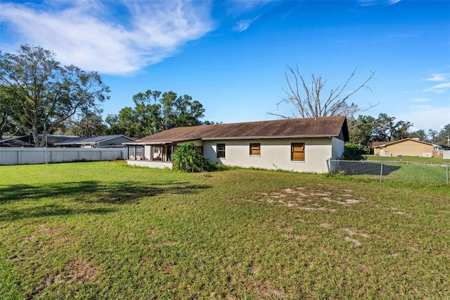 back of property with a lawn