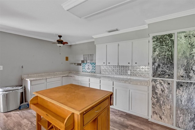 kitchen with light hardwood / wood-style flooring, white cabinets, and ornamental molding