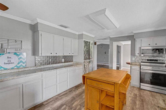 kitchen with stainless steel appliances, white cabinetry, light hardwood / wood-style floors, and crown molding