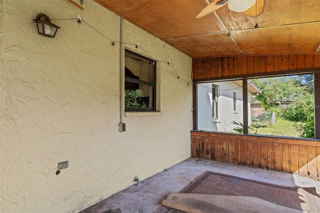 exterior space with ceiling fan, wooden ceiling, and wooden walls