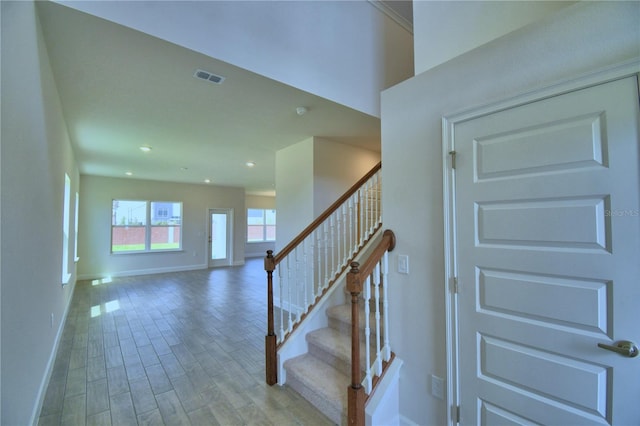 staircase featuring visible vents, baseboards, recessed lighting, and wood finished floors