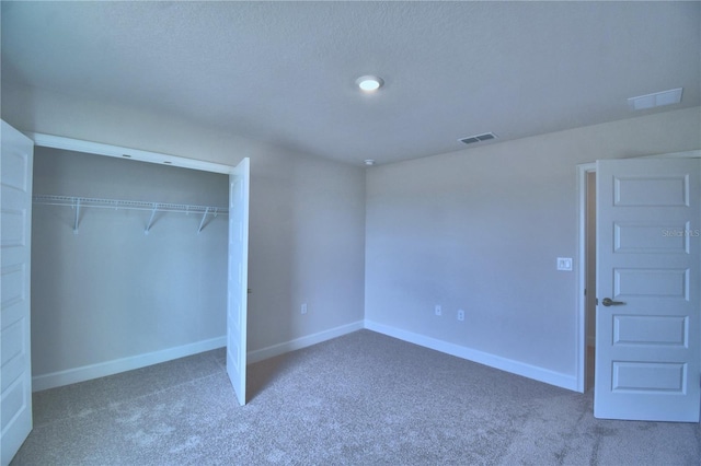 unfurnished bedroom featuring visible vents, baseboards, carpet flooring, and a closet