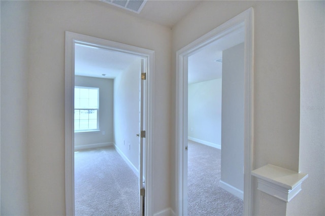 corridor with carpet, visible vents, and baseboards
