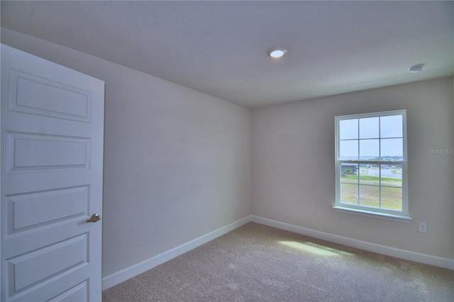 carpeted empty room with baseboards