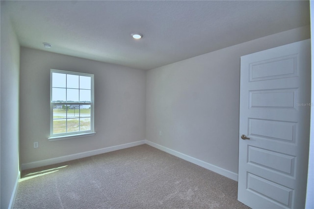 carpeted spare room with baseboards