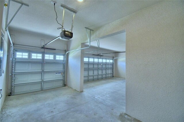 garage featuring a garage door opener and a textured wall