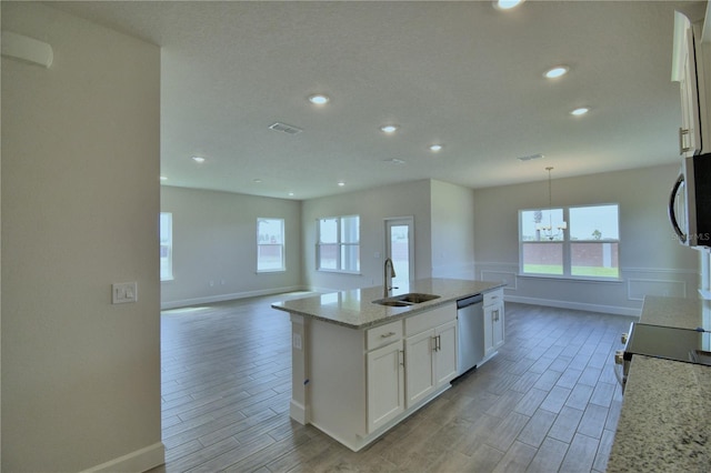 kitchen with visible vents, baseboards, white cabinets, a sink, and appliances with stainless steel finishes
