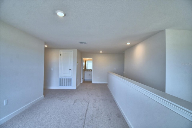 hallway with visible vents, baseboards, recessed lighting, and carpet flooring