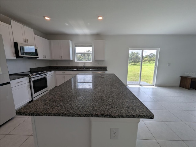 kitchen with white cabinetry, a kitchen island, and electric stove