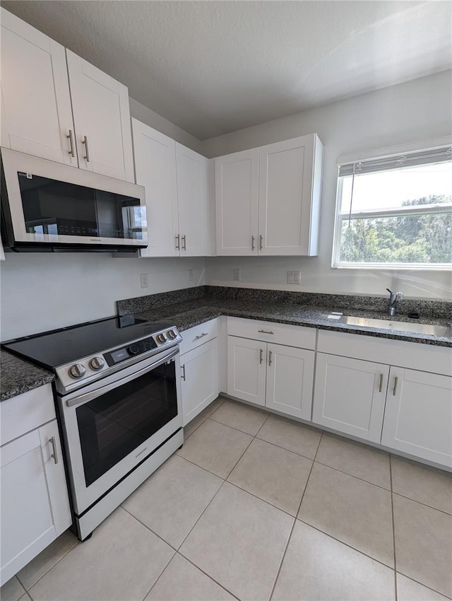 kitchen featuring light tile patterned flooring, sink, white cabinets, and stainless steel appliances