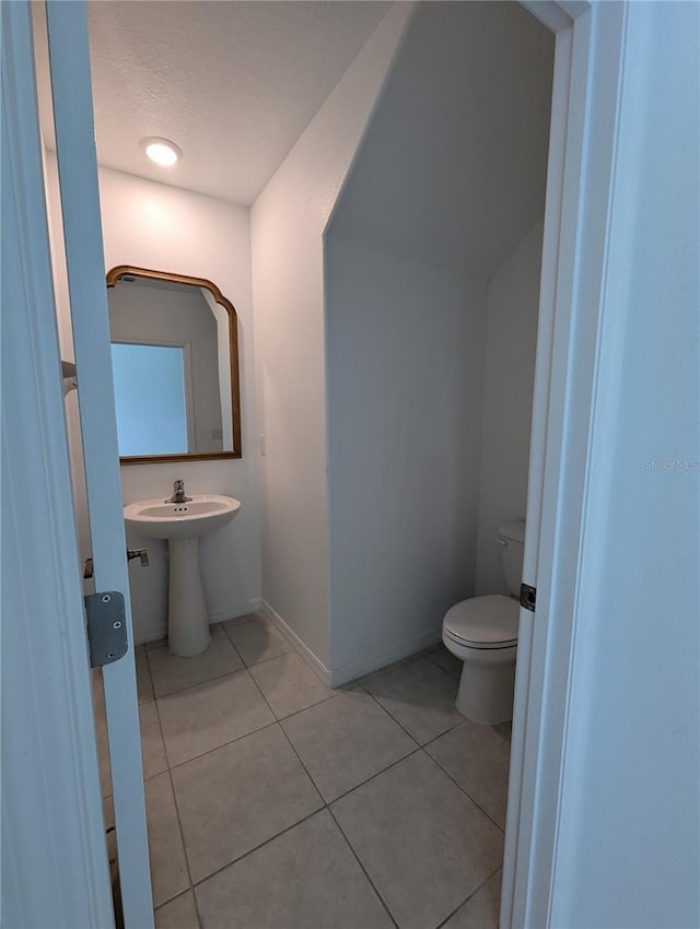 bathroom with toilet and tile patterned floors