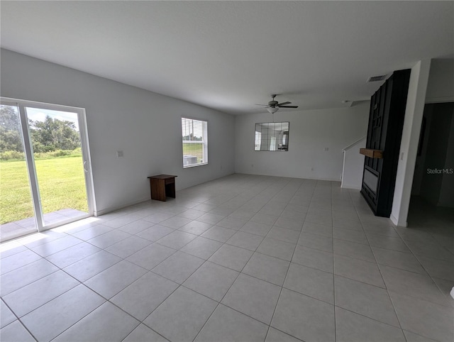 unfurnished living room with light tile patterned floors, ceiling fan, and a healthy amount of sunlight