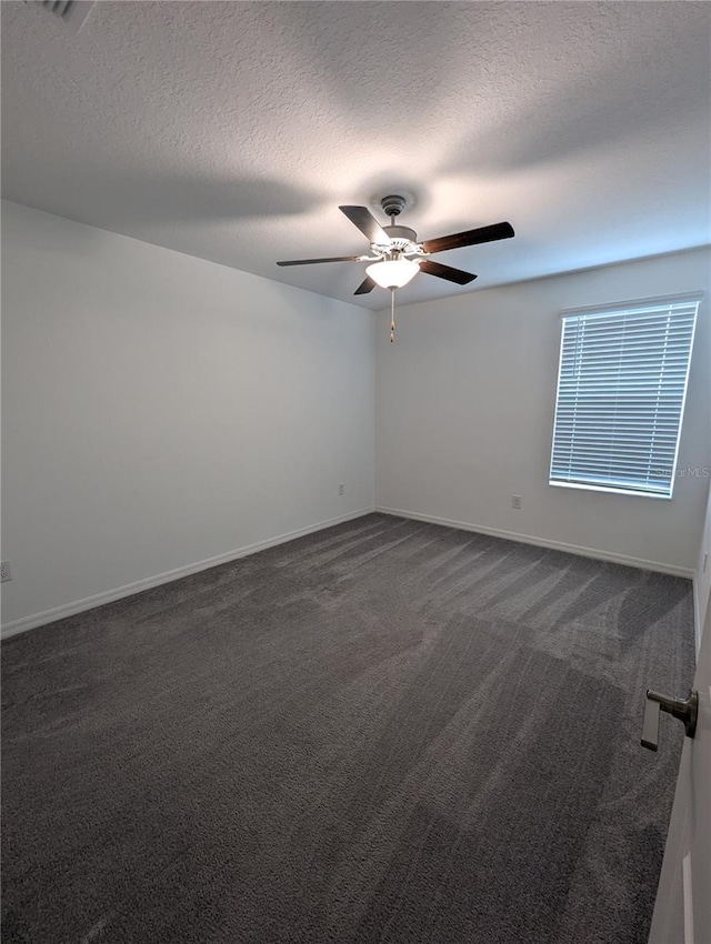 unfurnished room featuring dark colored carpet, a textured ceiling, and ceiling fan