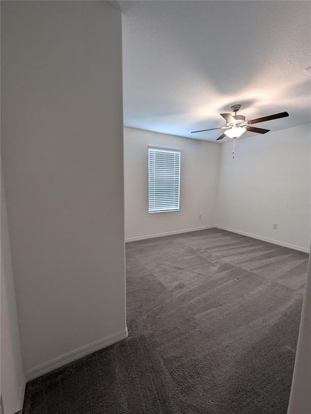 carpeted spare room featuring ceiling fan and a textured ceiling