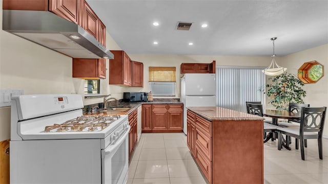 kitchen with white appliances, exhaust hood, sink, hanging light fixtures, and light tile patterned flooring