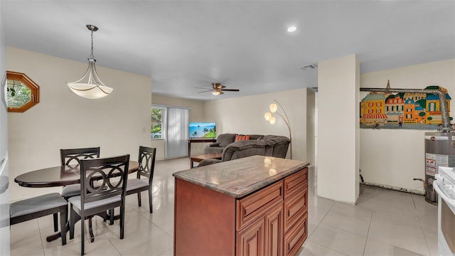 kitchen featuring gas water heater, ceiling fan, light tile patterned floors, a center island, and hanging light fixtures