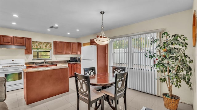 kitchen featuring decorative light fixtures, plenty of natural light, white appliances, and sink