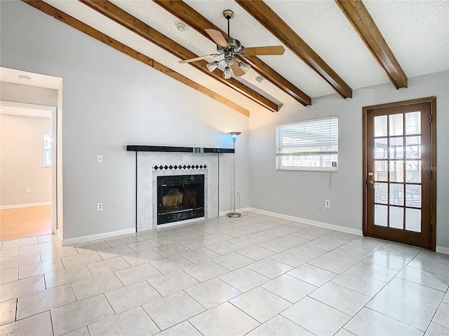 unfurnished living room featuring light tile patterned floors, lofted ceiling with beams, ceiling fan, and a tiled fireplace