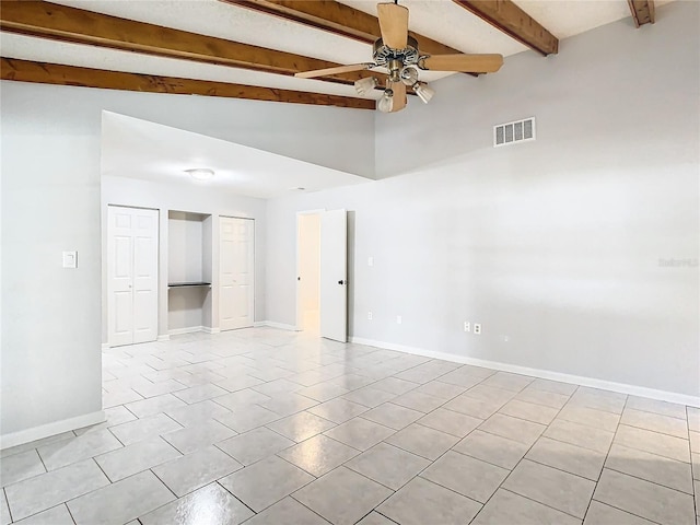 empty room featuring vaulted ceiling with beams, ceiling fan, and light tile patterned flooring