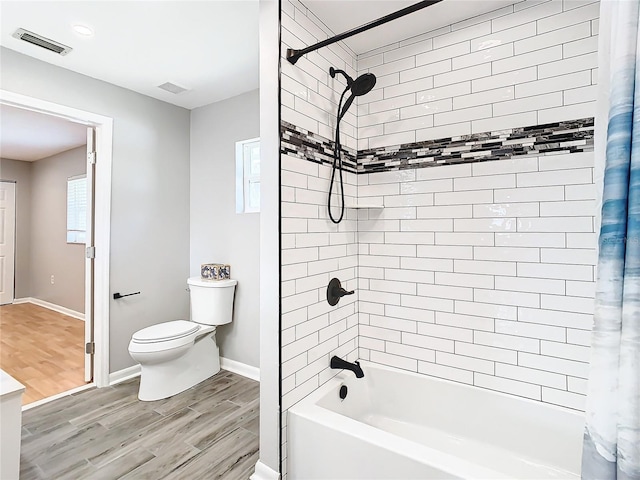 bathroom with hardwood / wood-style flooring, toilet, and shower / bathtub combination with curtain