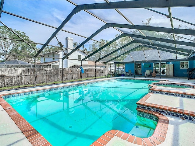 view of swimming pool featuring a patio area, a lanai, and an in ground hot tub