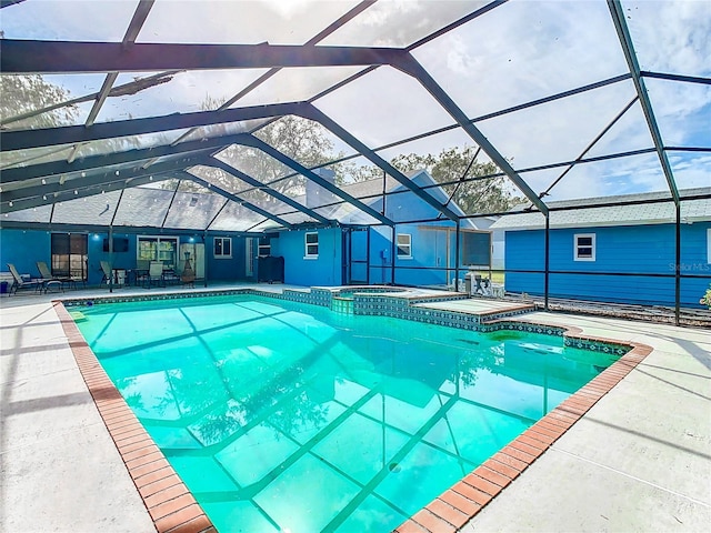 view of pool featuring a lanai, a patio area, and an in ground hot tub