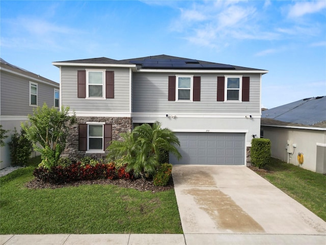 view of front property with solar panels, a front yard, and a garage