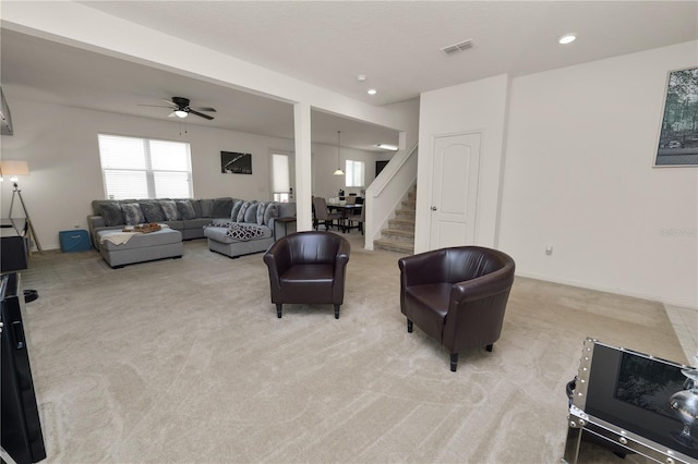 carpeted living room with ceiling fan