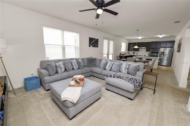 living room with ceiling fan and light colored carpet