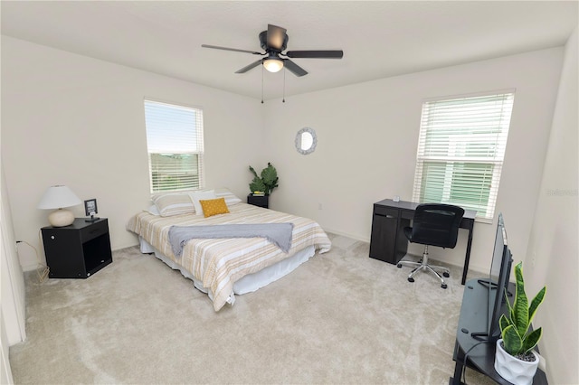 carpeted bedroom with multiple windows and ceiling fan