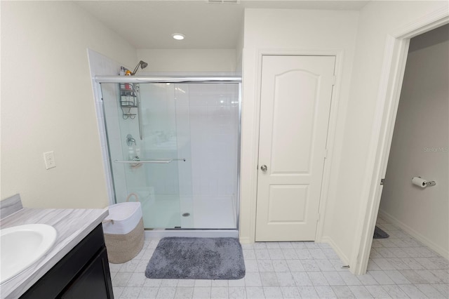 bathroom featuring tile patterned flooring, vanity, and a shower with shower door