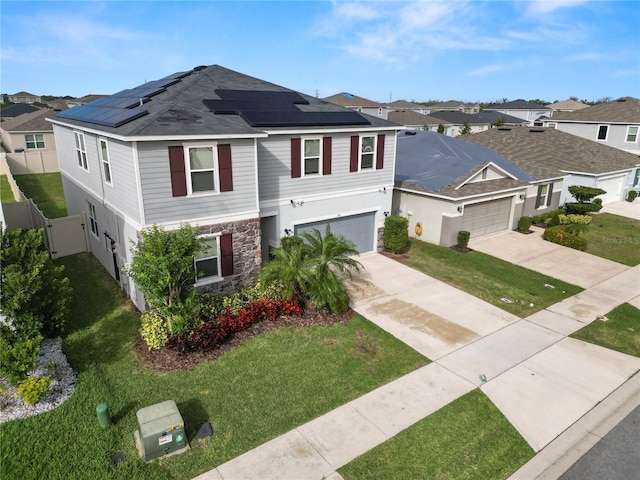 view of front of house with solar panels, a garage, and a front lawn